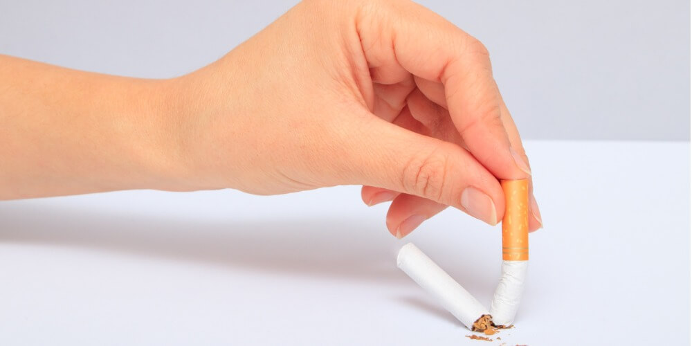 mano aplastando un cigarrillo. Nota sobre tabacoo y esclerosis multiple