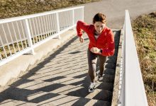 Happy sportswoman jogging at the bridge