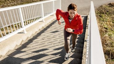 Happy sportswoman jogging at the bridge